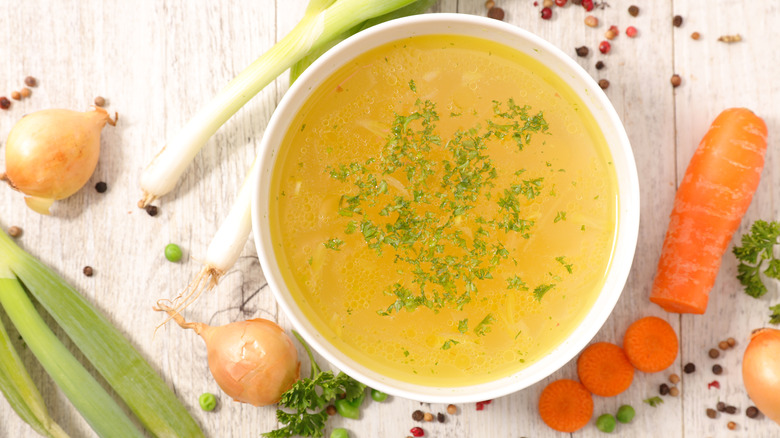 Stock in bowl with leeks, onions, and carrots