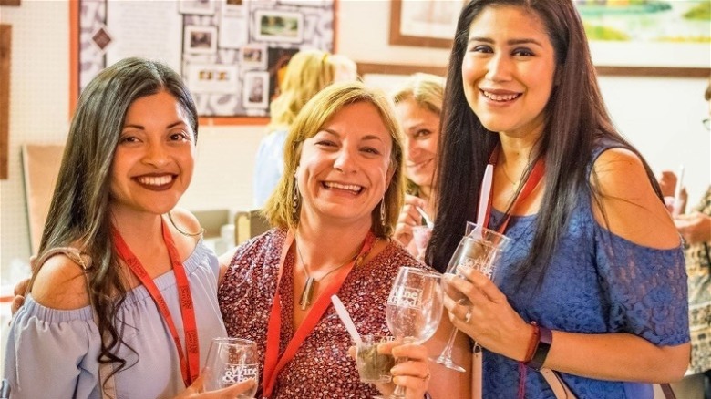 smiling women with wine glasses