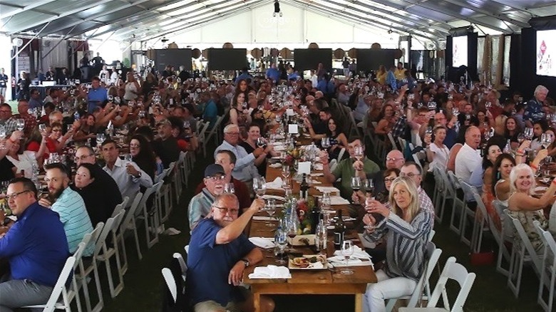 multiple long banquet tables of people