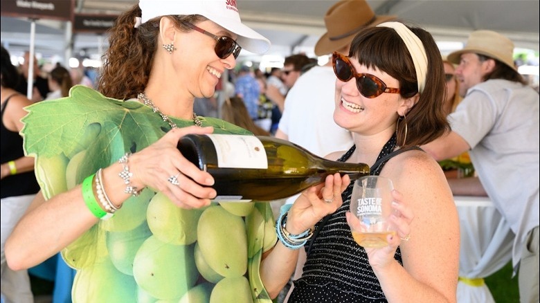 woman pouring wine for someone