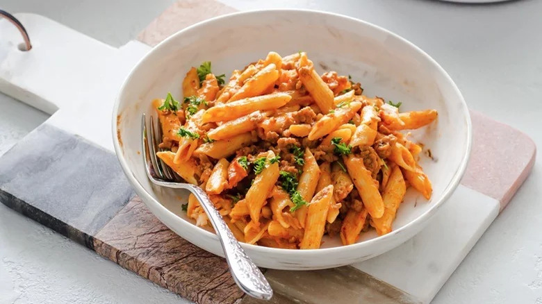 Ground turkey penne casserole in a bowl with a fork