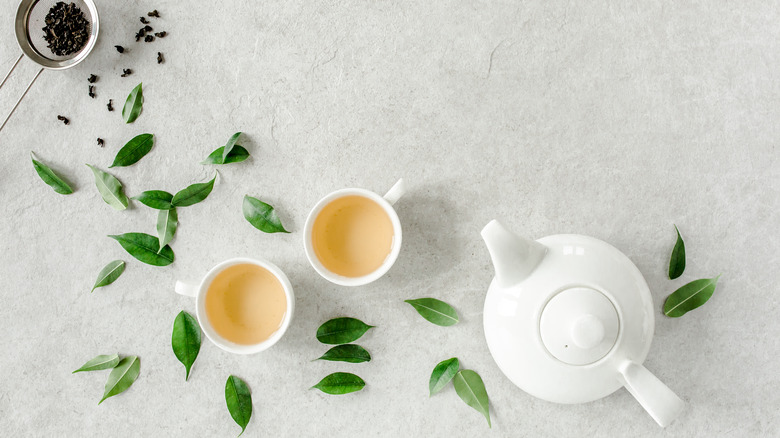 Green tea in cups with teapot