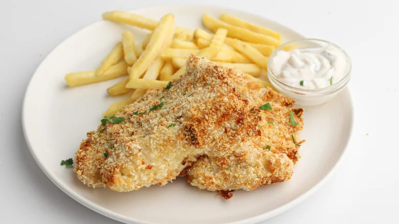 Breadcrumbed fish with French fries and creamy sauce