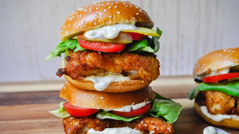 Fried fish burger buns with salad and dill pickle