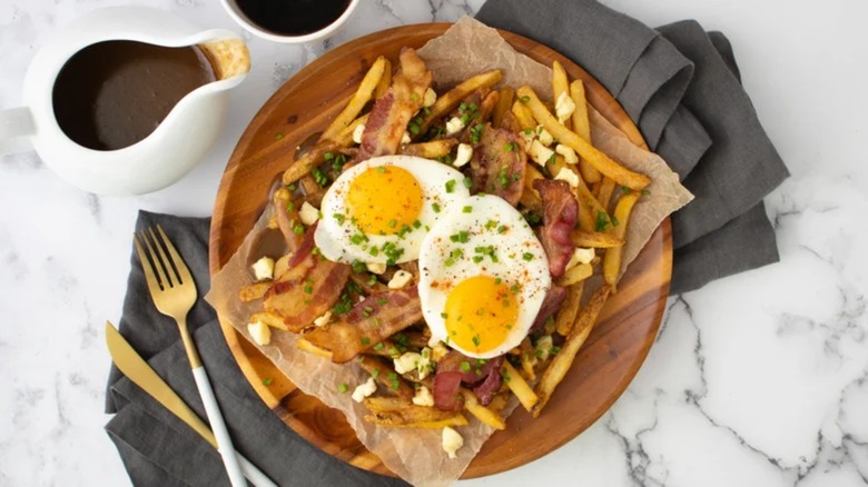 Breakfast poutine on wooden plate