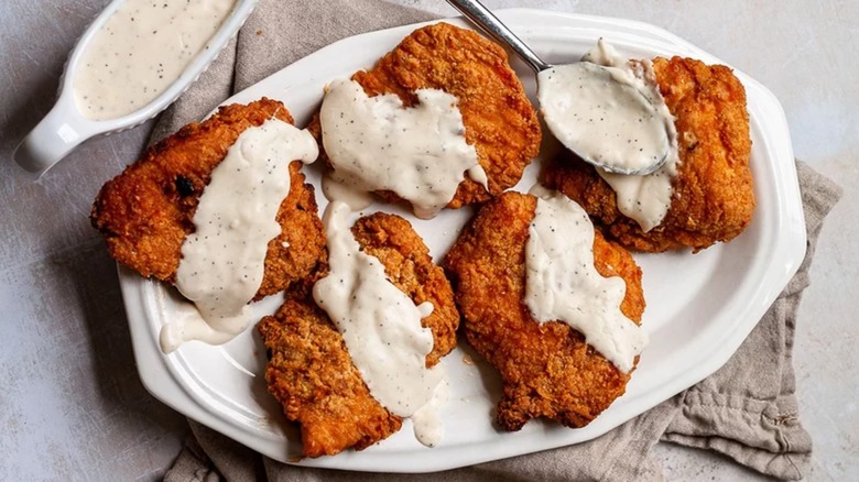 White gravy covering fried chicken