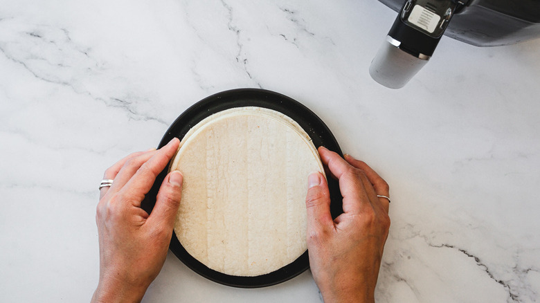 holding corn tortillas on plate