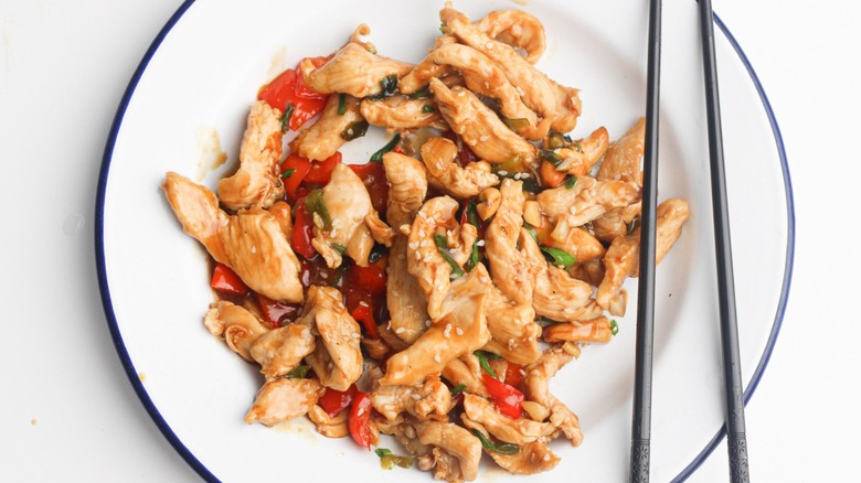 Cashew chicken on plate with chopsticks