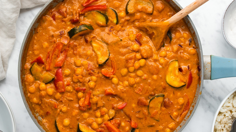 Finishing cooking chickpea curry in pan 