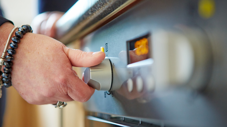 turning knob to preheat oven  