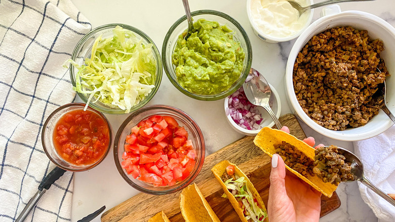 adding toppings to lentil tacos  
