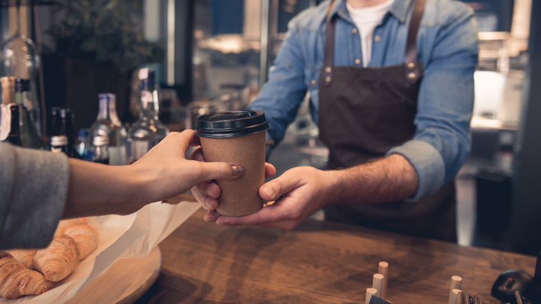 serving coffee to customer at coffee shop