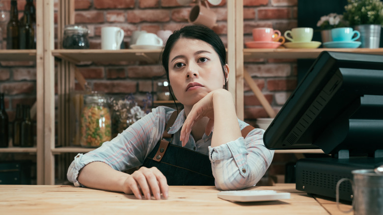 a sad looking barista at coffee shop