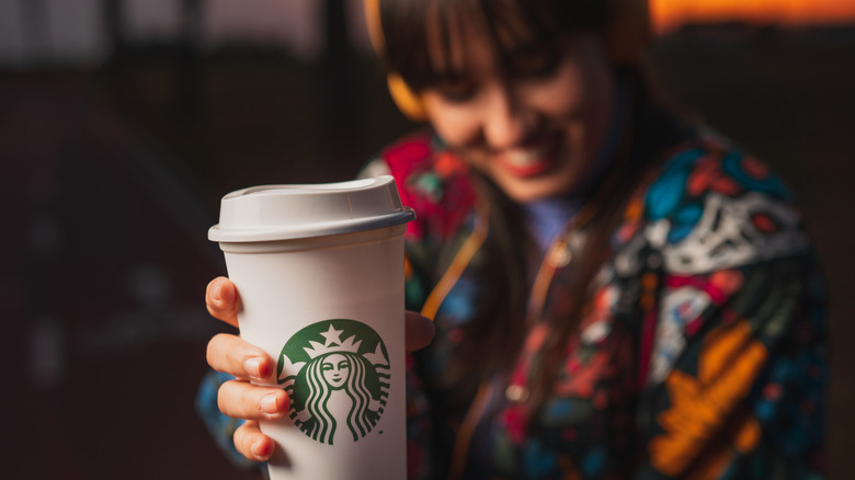 woman holding a Starbucks cup