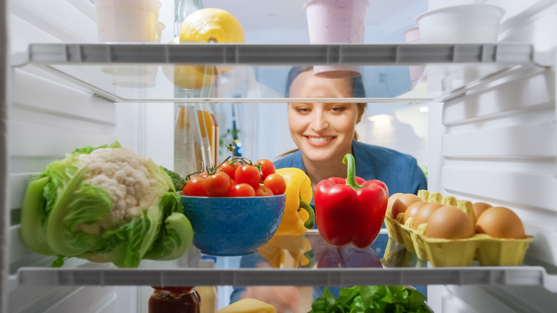 Woman looks into refrigerator