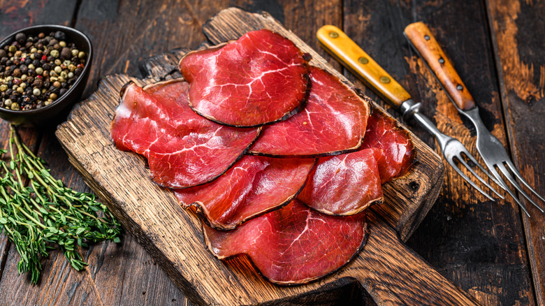 Bresaola slices on chopping board