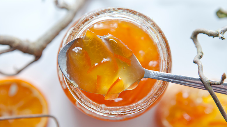 overheat shot of apricot jam with spoon in jar