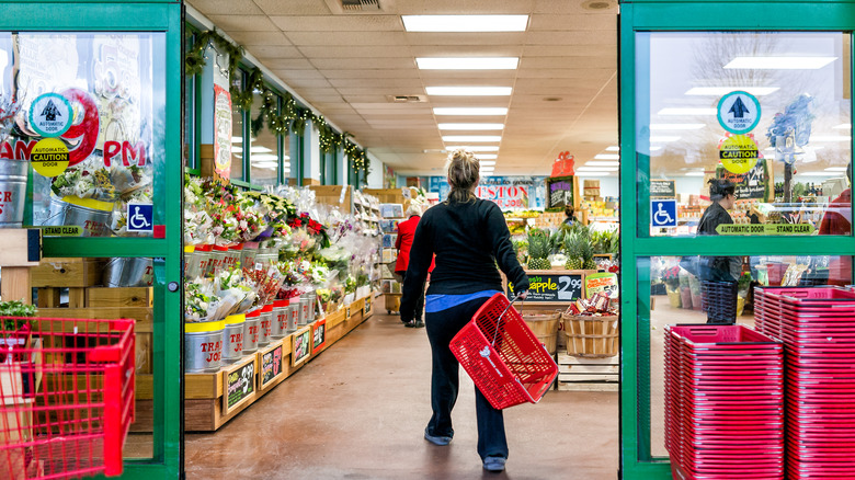 Woman walking into Trader Joe's with basket