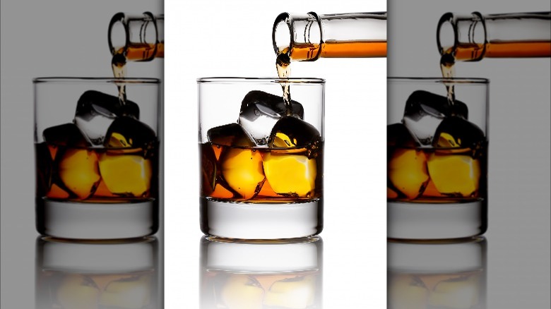 pouring whiskey over ice cubes