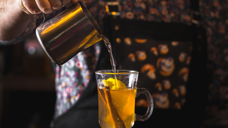 pouring whiskey hot toddy drink