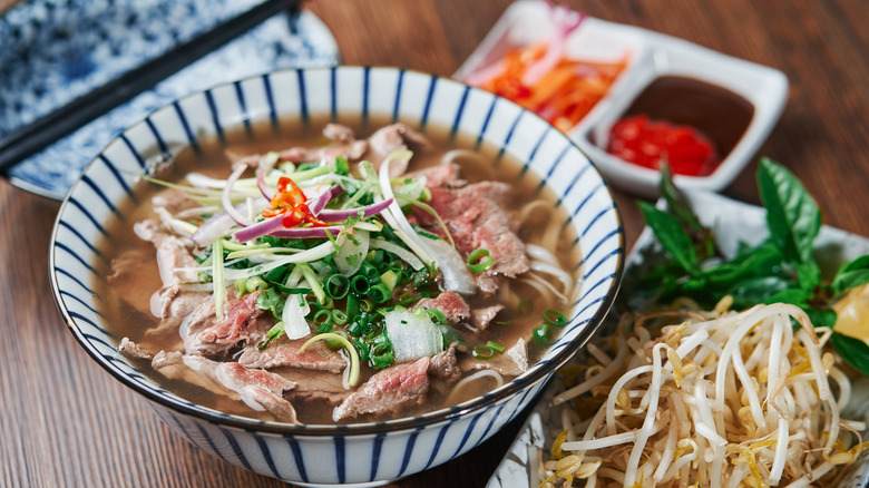 Bowl of phở with toppings on side