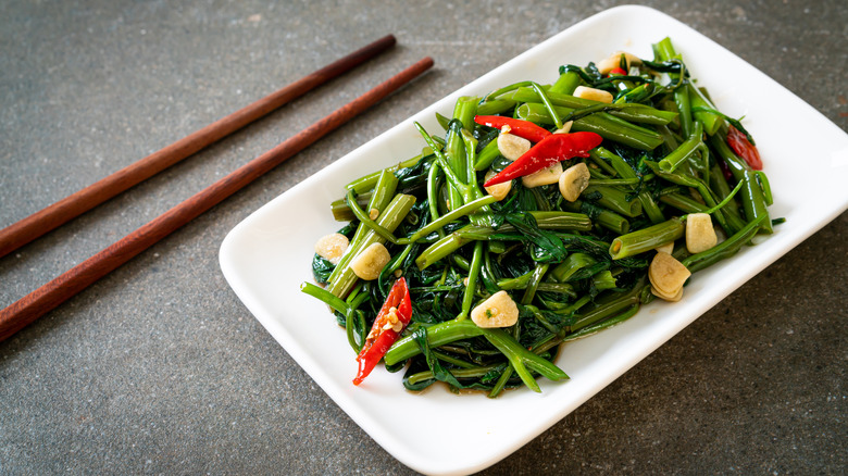 A plate of stir-fried morning glory with garlic