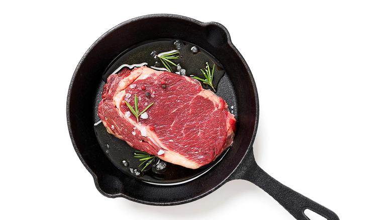 Raw steak in a cast iron pan