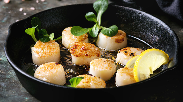 Scallops cooking in a cast iron skillet