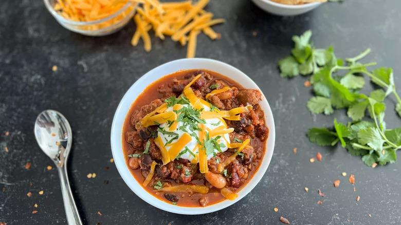 Chili bowl with grated cheese and sour cream 