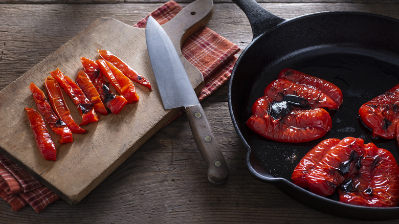 roasted red peppers in pan and on cutting board