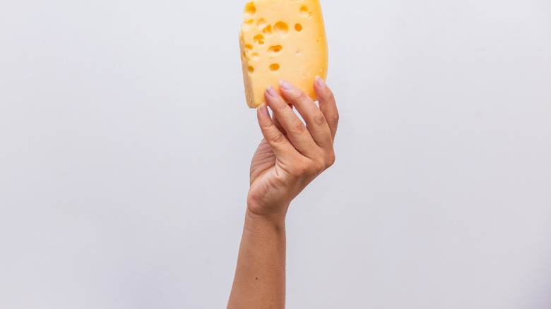 hand holding up emmentaler