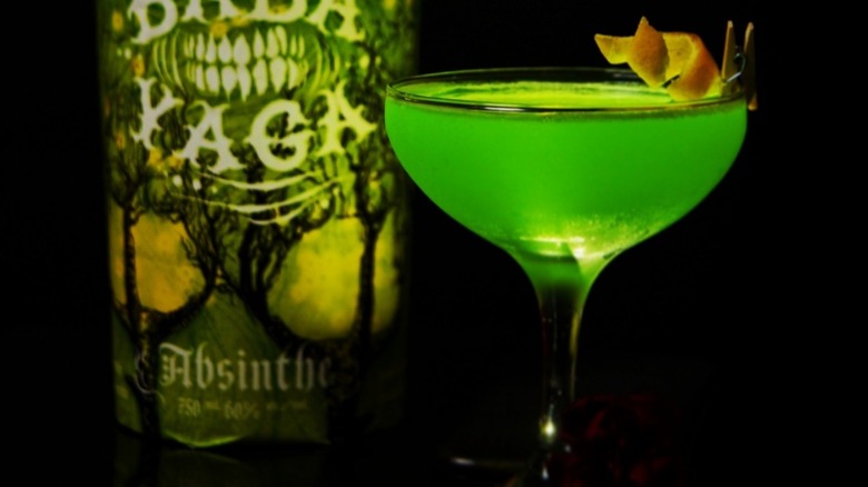 Green cocktail with absinthe bottle
