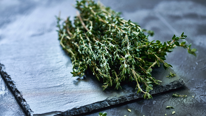 bunch of thyme sprigs on chopping board