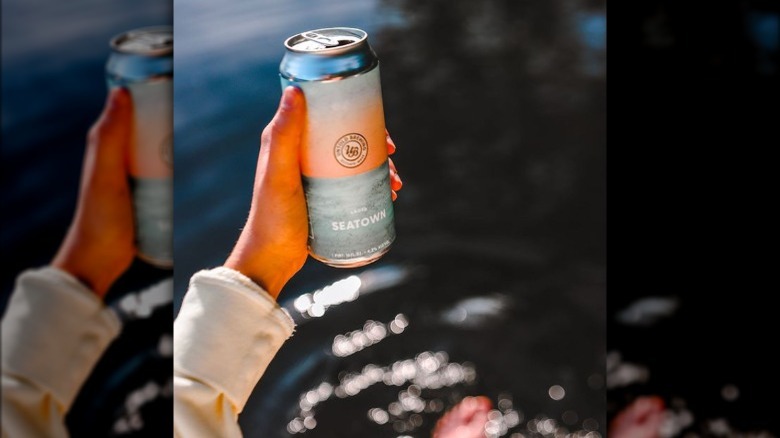 holding beer can over water