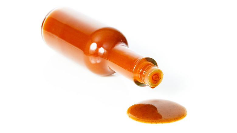 hot sauce bottle with puddle of hot sauce below