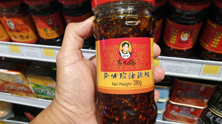 hand holding lao gan ma chili crisp jar