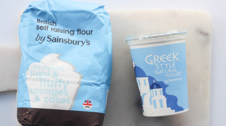 Sainsbury's self-raising flour and Greek yogurt placed on the table.