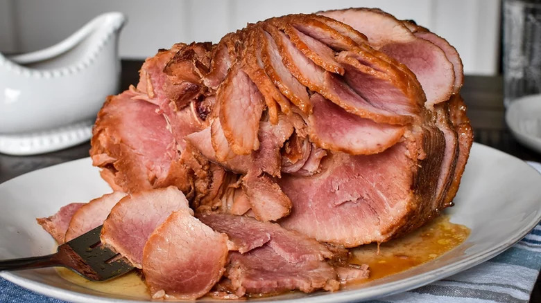 Spiral-cut honey-baked ham with sauce boat