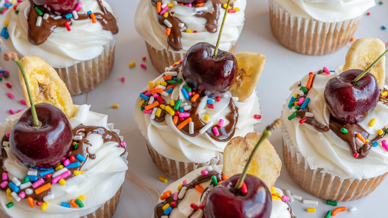 Cupcakes topped with sprinkles and cherries