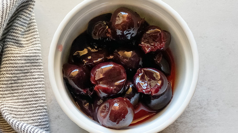 White bowl of syrupy cherries