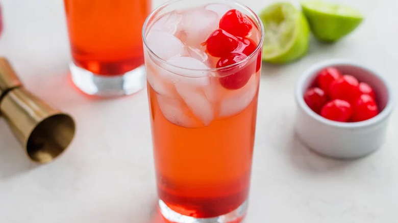 Glass with red liquid, cherries, and ice