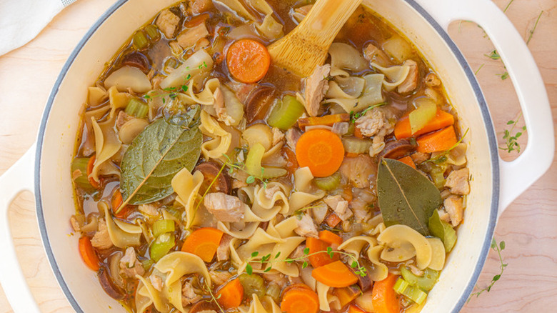 Dutch oven with chicken, noodle, and vegetable soup.