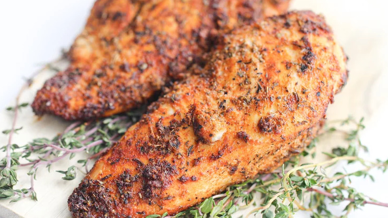 Cooked chicken breasts with seasonings. 