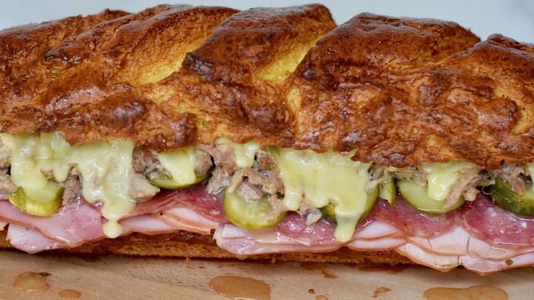 Broiled Cuban sandwich with deli meats, cheese, and pickles.