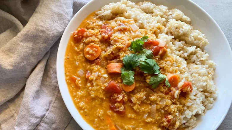 Large bowl with rice, lentil broth, carrots, and cilantro.