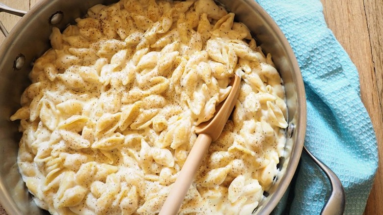 Shell pasta with cheese sauce and pepper in large skillet. 