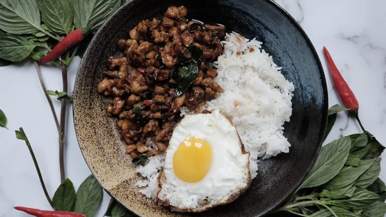 Diced cooked chicken in sauce with fried egg and rice.