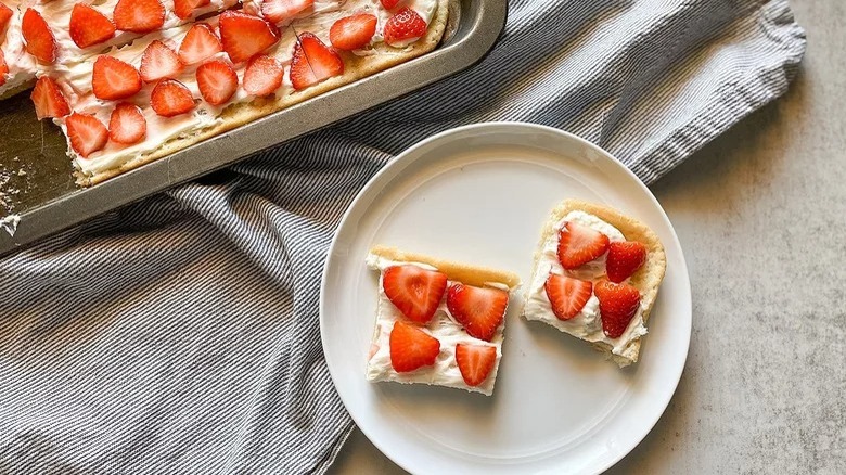 pan and plate of sliced strawberry dessert pizza