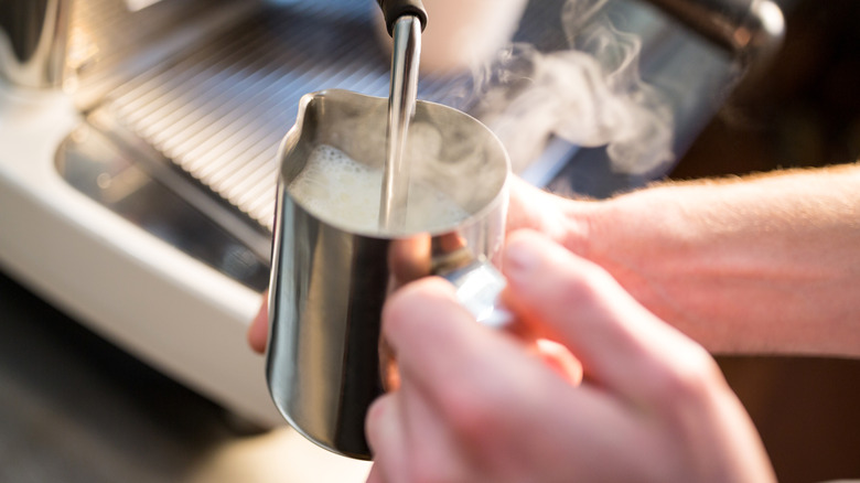 An espresso machine steamer frothing a liquid