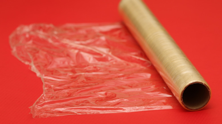 A roll of plastic wrap with a red background